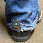 Decorative Sunflower Cowgirl Cuff attached to the back of a cowboy boot helping keep jean hems off the ground while adding western floral style.