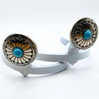 Close-up of the Decorative Sunflower Cowgirl Cuff featuring a turquoise-style center stone, radiating sunflower pattern, and western metalwork details.