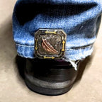 Feather with Arrows Cowgirl Cuff attached to the back of a cowboy boot helping keep jean hems off the ground while adding western feather and arrow styling.