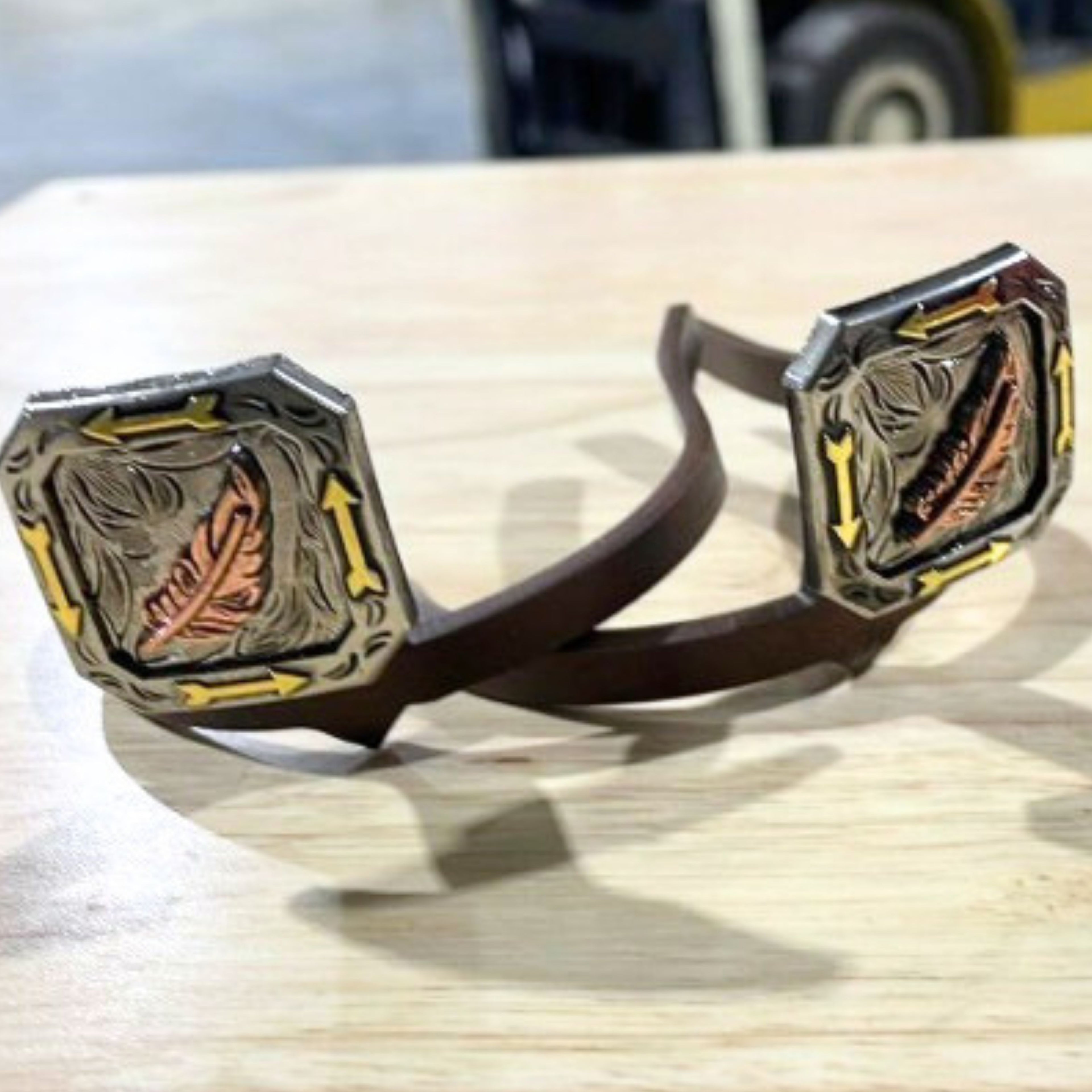 Handcrafted Feather with Arrows Cowgirl Cuff featuring a copper feather centerpiece, engraved western details, arrow accents, and mixed-metal finishes.