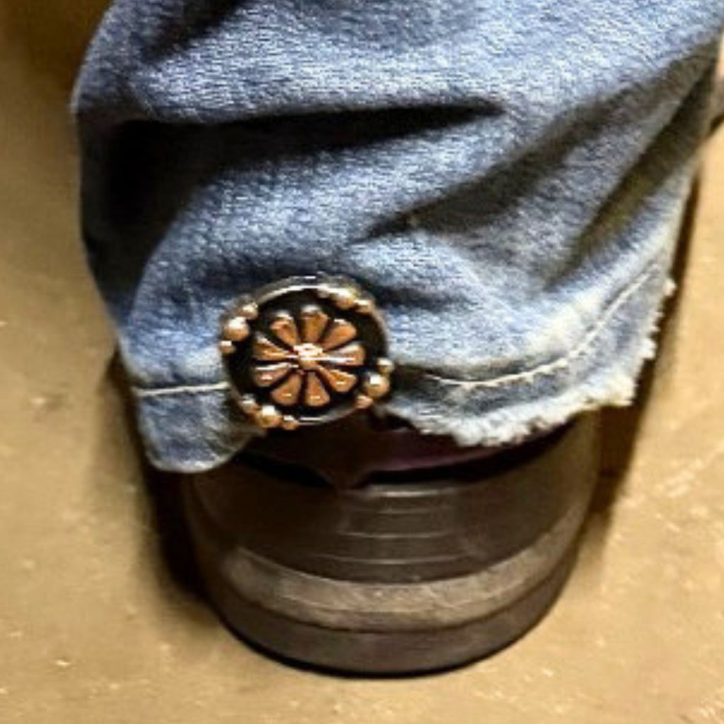 Oaxaca Floral Concho Cowgirl Cuff attached to a cowboy boot, featuring copper-tone floral detailing, black enamel accents, and western styling designed to keep jean hems off the ground.
